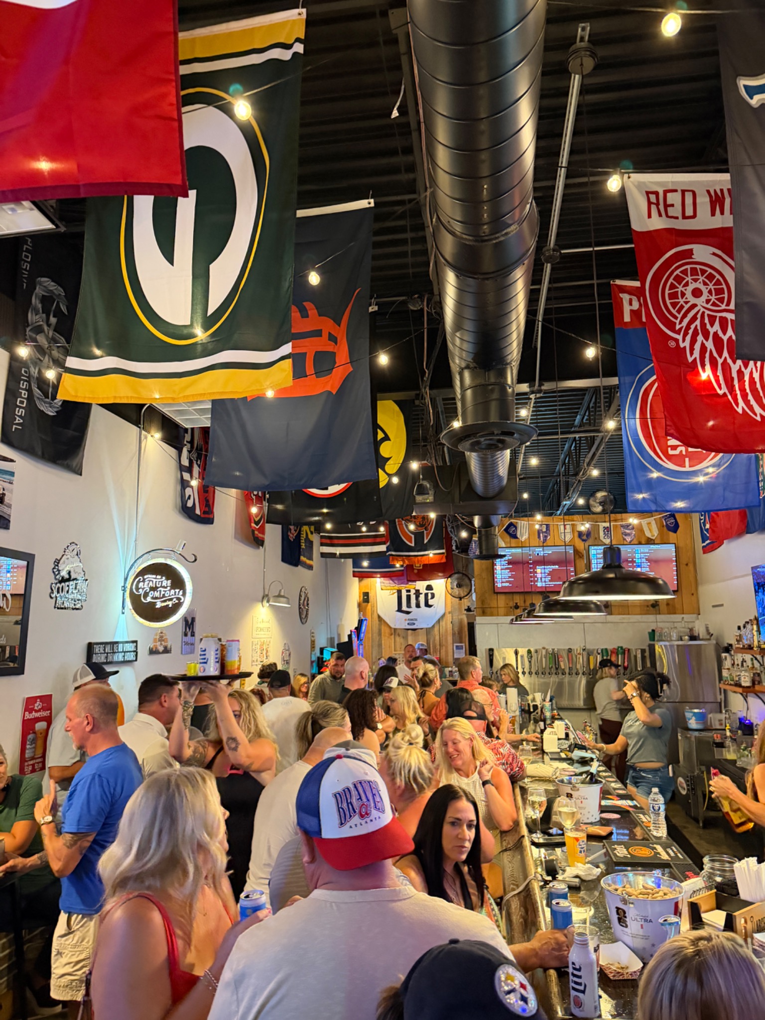 Guests gathered around the bar for drinks and conversation at Neighbors
